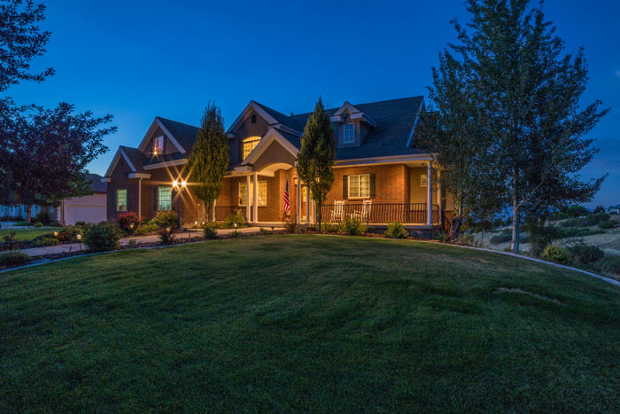 Suburban house at night with lights on, related to mom throwing kid out for not making bed on cold Christmas night.