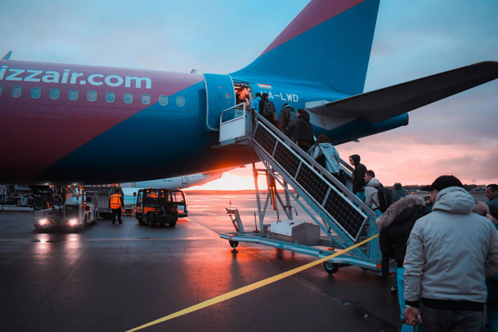 Passengers boarding a plane during sunset, illustrating a mom insisting woman give up her seat on a long flight conflict.