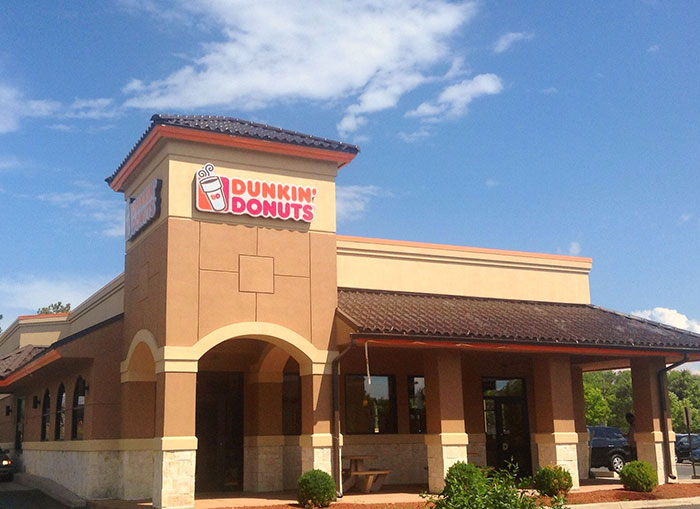 Dunkin Donuts storefront on a sunny day, related to con artist Karen stopped by customer loopholes.