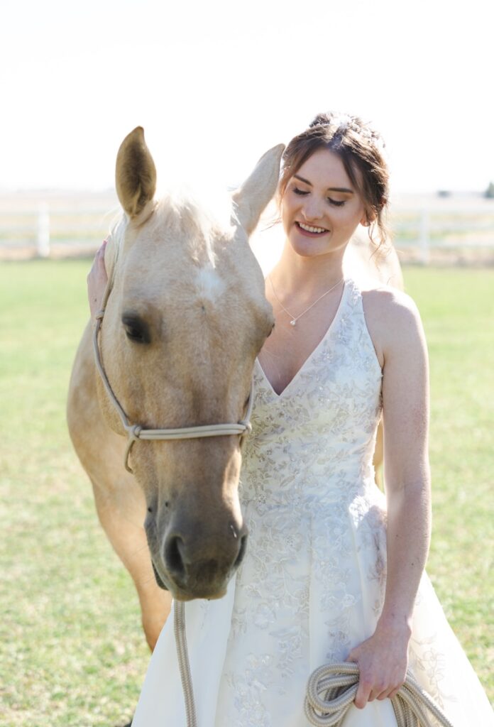 Bride poses with a horse on her wedding day.